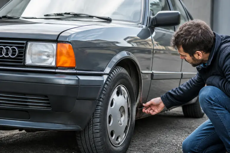 inspection minutieuse des passages de roue d une audi 80 youngtimer pour reperer la corrosion