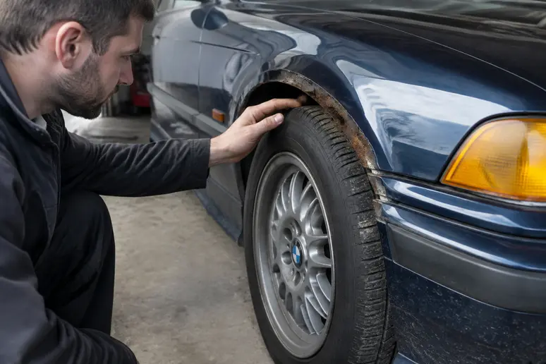 Inspection minutieuse de la rouille sur le passage de roue d une BMW E36 youngtimer