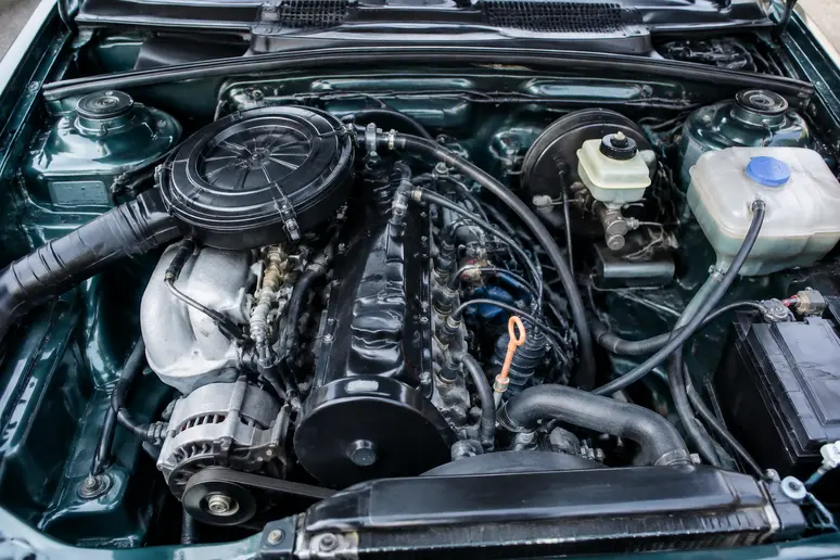Le compartiment moteur d'une Audi 80 1.8 E bien entretenue montrant ses performances.