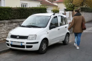 Un propriétaire s'approche de sa voiture pour évaluer la cote fiat panda sur le marché.