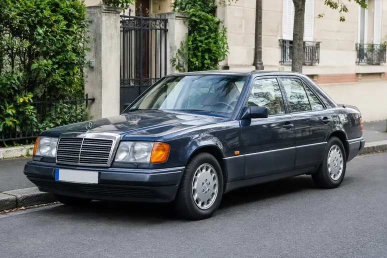 Mercedes W124 garée dans une rue résidentielle illustrant la diversité des modèles d'occasion
