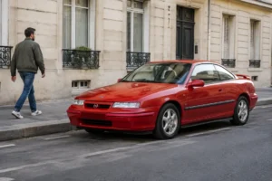 Un exemplaire rouge d'une cote opel calibra garé dans une rue résidentielle en journée
