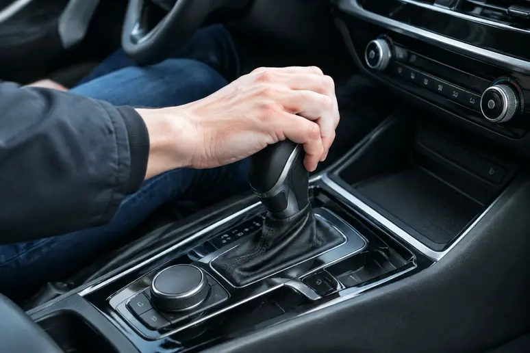 Mains d'un conducteur testant la transmission d'un crossover lors d'un essai routier