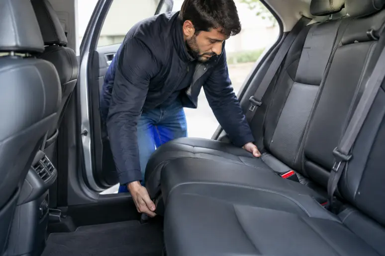 Un acheteur vérifie le verrouillage de la banquette arrière à bord d'un crossover pour s'assurer de sa fiabilité nissan juke