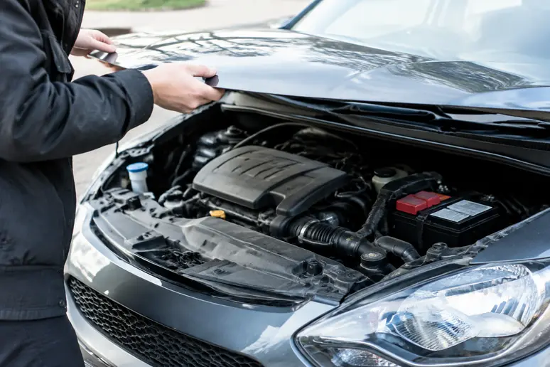 Vérification de la motorisation sous le capot d'une voiture occasion jeune conducteur