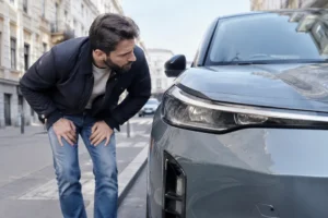Un acheteur examine une voiture électrique d'occasion en consultant la cote renault 5 sur le marché.