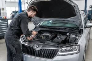 Un mécanicien examine le moteur dans un garage pour évaluer la fiabilité skoda fabia d'occasion.