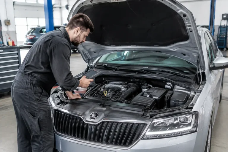 Un mécanicien examine le moteur dans un garage pour évaluer la fiabilité skoda fabia d'occasion.